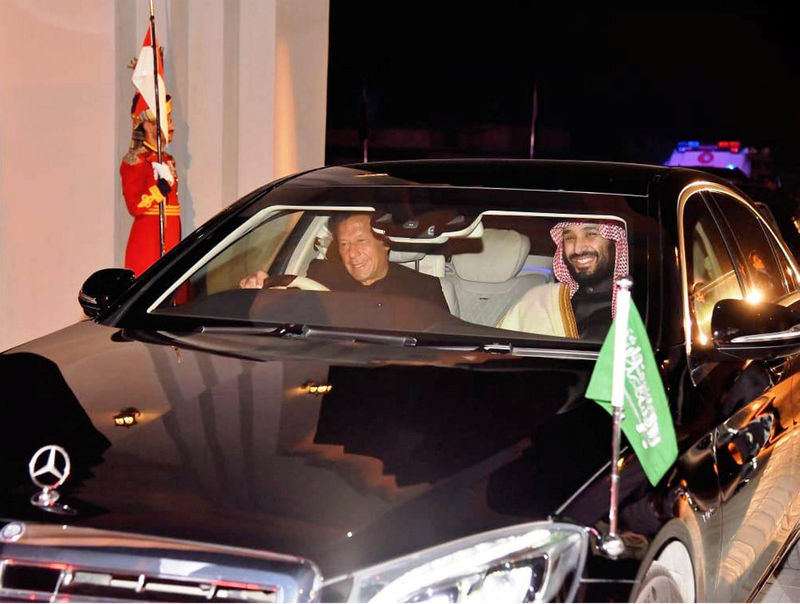 © Reuters. Pakistani Prime Minister Imran Khan drives a vehicle as he receives Saudi Arabia's Crown Prince Mohammed bin Salman on his arrival at Pakistan Air Force Nur Khan Base in Rawalpindi