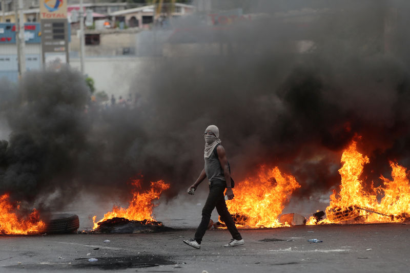 © Reuters. Un manifestante enciende barricadas durante una protesta contra el gobierno en Puerto Príncipe