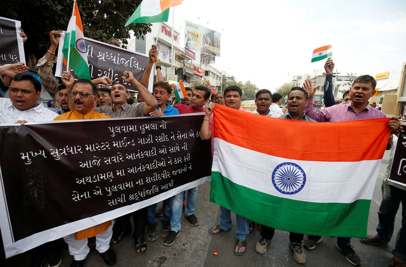 © Reuters. Manifestantes seguram bandeiras da Índia durante protesto contra ataque na Caxemira
