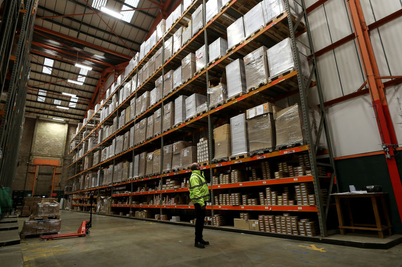 © Reuters. FILE PHOTO: An employee looks up at goods at the Miniclipper Logistics warehouse in Leighton Buzzard