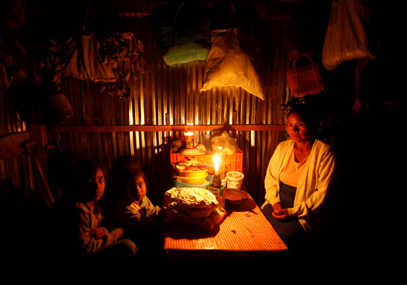 © Reuters. FILE PHOTO: A woman sits with her grandchildren at their home on the outskirts of Oaxaca