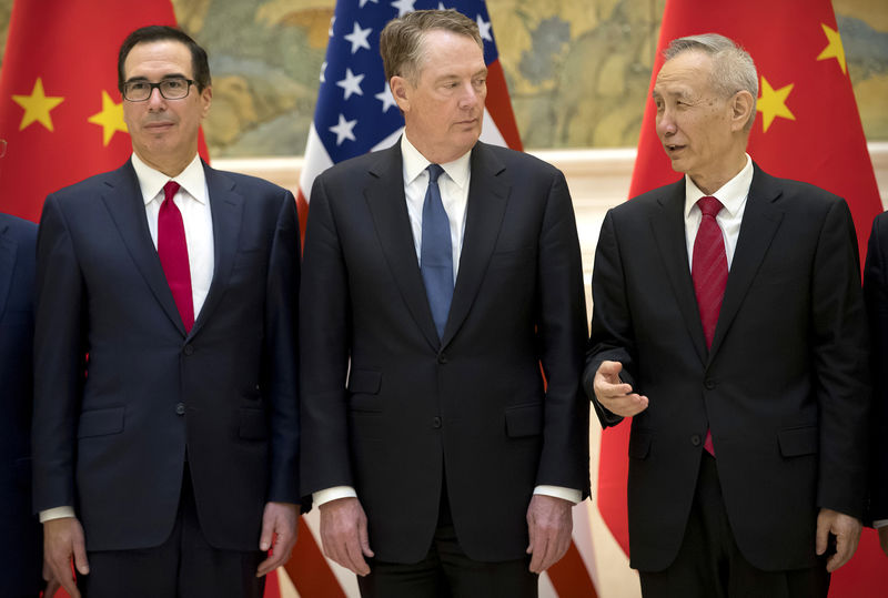© Reuters. U.S. Trade Representative Robert Lighthizer, listens as Chinese Vice Premier Liu He, talks while they line up for a group photo at the Diaoyutai State Guesthouse in Beijing