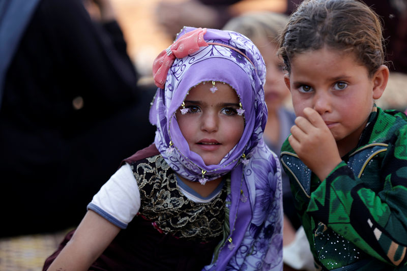 © Reuters. Niños sirios desplazados reaccionan luego de llegar a un campamento de refugiados en la aldea de Atimah, provincia de Idlib