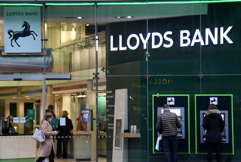 © Reuters. FILE PHOTO: Customers use ATMs at a branch of Lloyds Bank in London