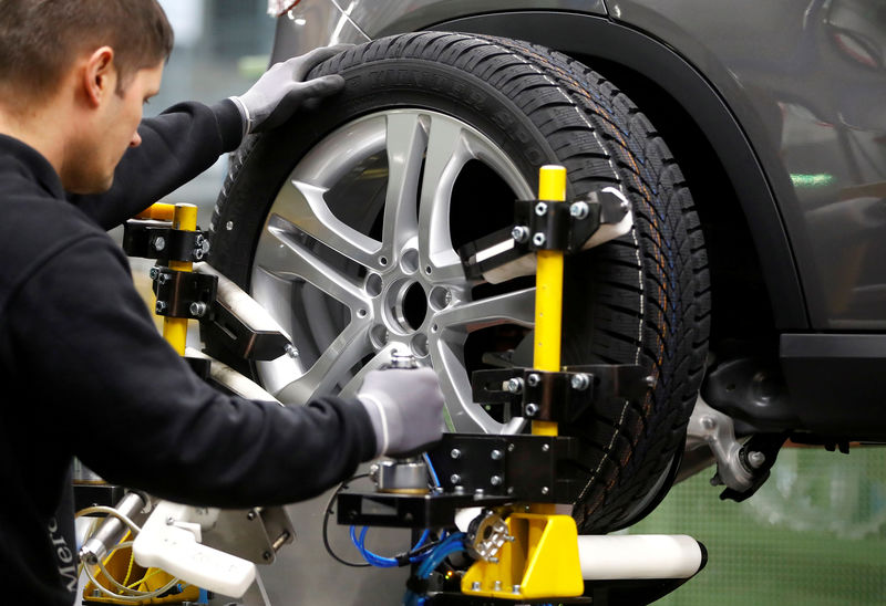 © Reuters. FILE PHOTO: An employee of German car manufacturer Mercedes Benz installs wheel at a A-class model at the production line at the Daimler factory in Rastatt
