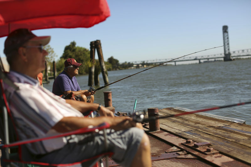 © Reuters. Retirees fish from a public dock on the Sacramento River in the Sacramento San Joaquin River Delta in Rio Vista, California