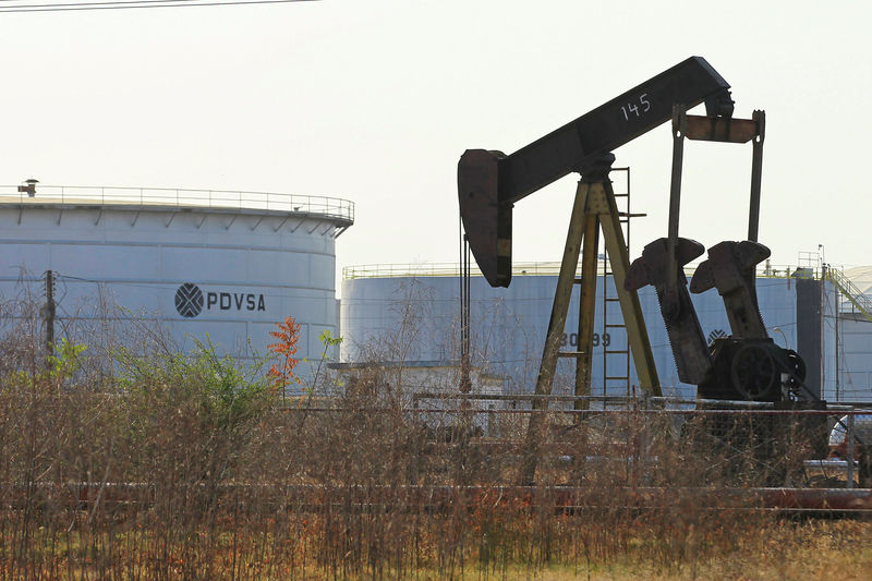 © Reuters. Станок-качалка и нефтехранилище с логотипом PDVSA в Лагунильясе, Венесуэла