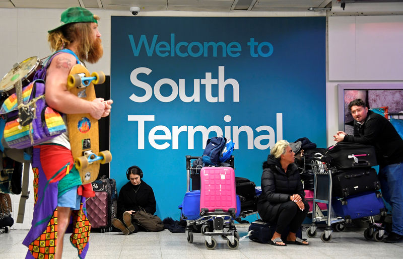 © Reuters. Passengers wait in the South Terminal building at Gatwick Airport, after the airport reopened to flights following its forced closure because of drone activity, in Gatwick