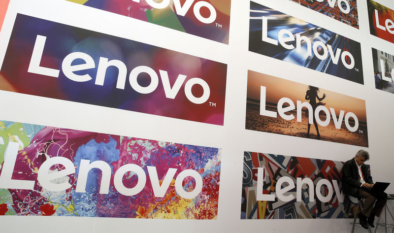 © Reuters. Homem usa computador em frente a logos da Lenovo em congresso.