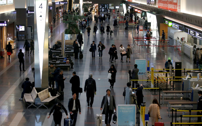 © Reuters. FILE PHOTO: Passengers are seen in front of security check at the Tokyo International Airport in Tokyo