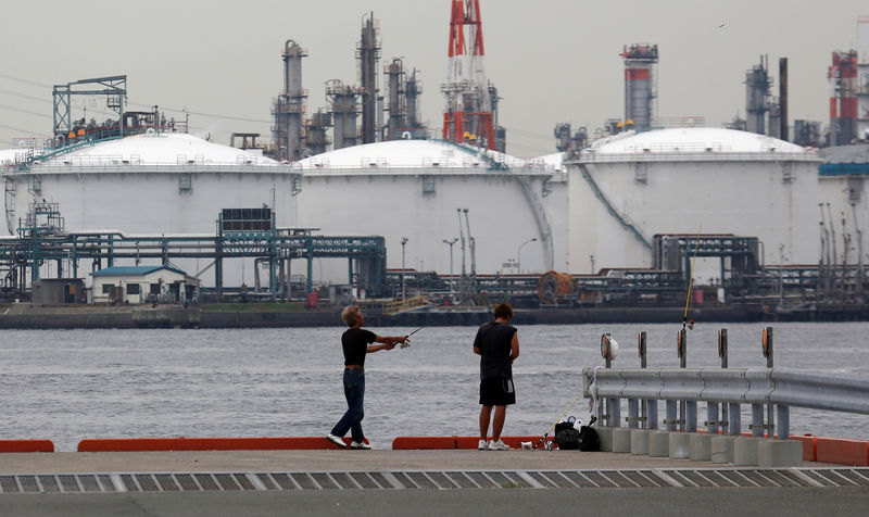 © Reuters. FILE PHOTO: FILE PHOTO:  Men fish near an oil refinery in Kawasaki, near Tokyo