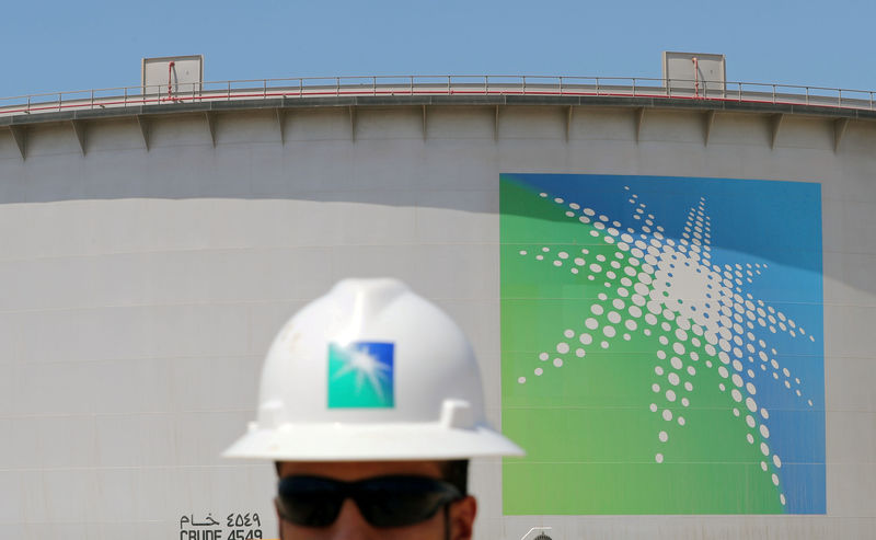 © Reuters. FILE PHOTO: An Aramco employee walks near oil tank at Saudi Aramco's Ras Tanura oil refinery and oil terminal