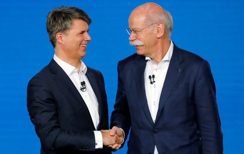© Reuters. Harald Kruger, CEO and Chairman of the Board of Management of BMW AG and Dieter Zetsche, CEO of Daimler AG, shake hands at a news conference to present plans for combining the companies' car-sharing businesses, in Berlin