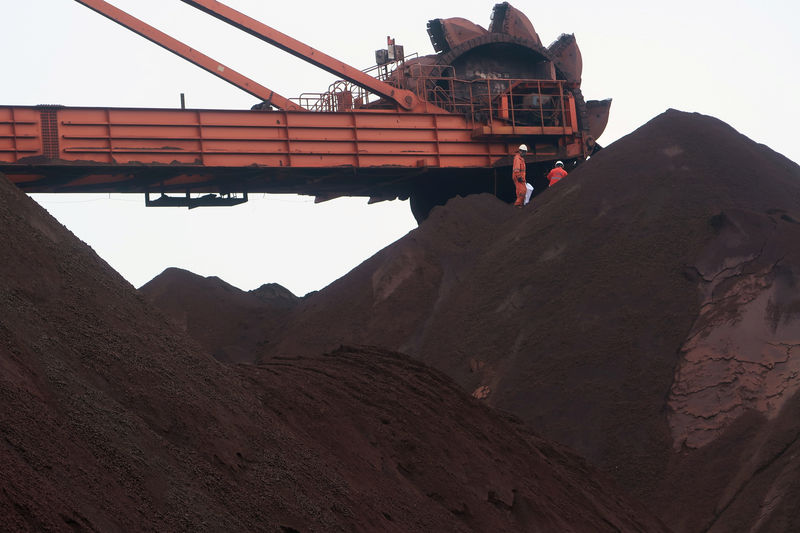 © Reuters. Trabalhadores em pilha de minério de ferro na China