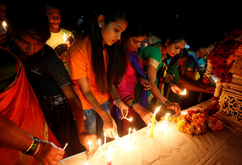 © Reuters. Pessoas durante vigília em homenagem a policiais paramilitares indianos que morreram em ataque com carro-bomba no sul da Caxemira na semana passada em Ahmedabad, Índia