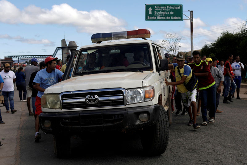 © Reuters. An ambulance carrying people that were injured during clashes in the southern Venezuelan town of Kumarakapay is assisted by people at the border between Venezuela and Brazil, in Pacaraima