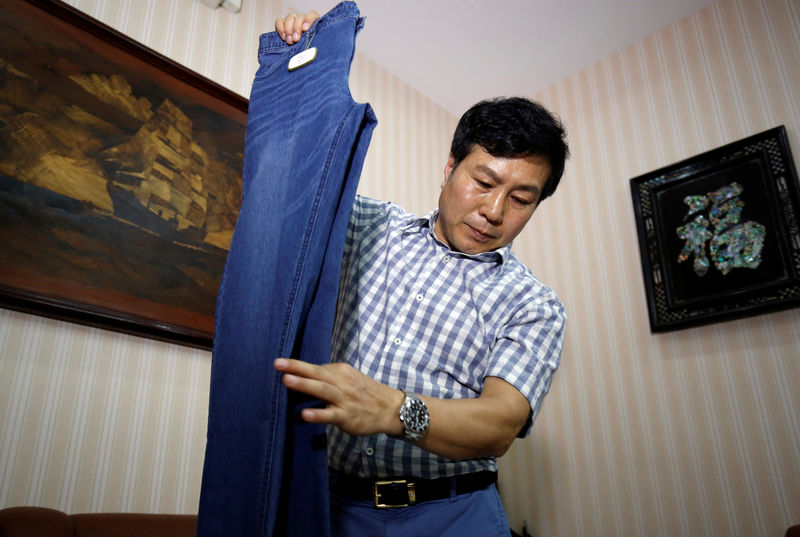 © Reuters. Choi Dong-jin, president of South Korean garment maker DMF, shows his product made in Kaesong at his office in Hanoi