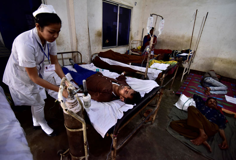© Reuters. Foto del sábado de una enfermera atendiendo a una persona que tomó licor adulterado en un hospital en la localidad india de Assam