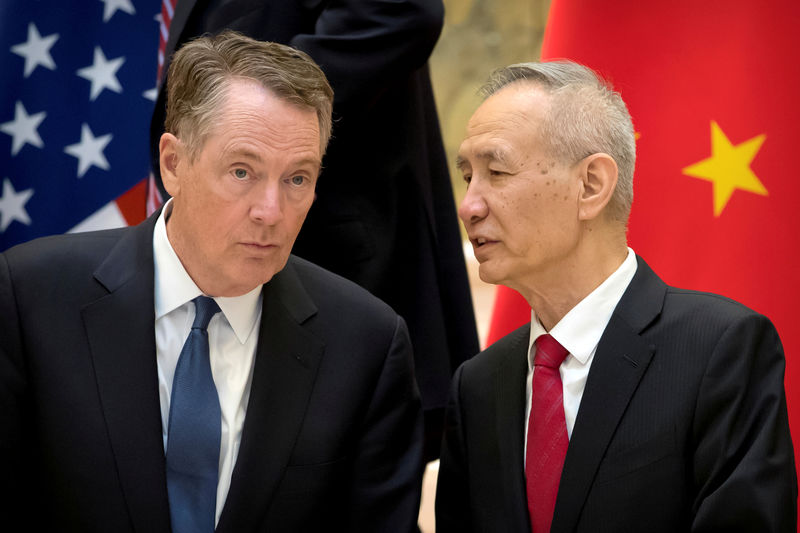 © Reuters. FILE PHOTO: U.S. Trade Representative Robert Lighthizer listens as Chinese Vice Premier Liu He talks while they line up for a group photo at the Diaoyutai State Guesthouse in Beijing