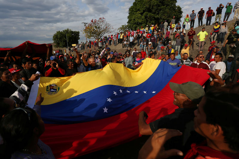 © Reuters. Manifestantes seguram bandeira da Venezuela durante protesto favorável ao governo na fronteira entre o país e o Brasil