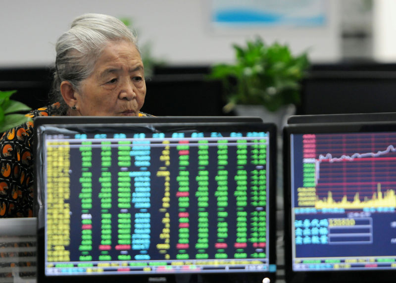 © Reuters. Woman looks at monitors showing stock information at a brokerage house in Jiujiang