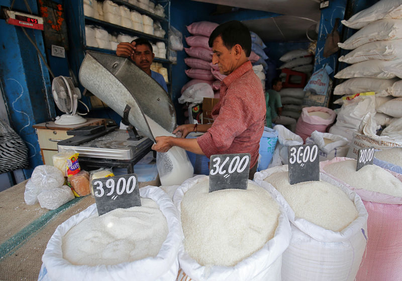 © Reuters. FILE PHOTO:  A man packs sugar for sale inside a shop at a marketplace in Ahmedabad