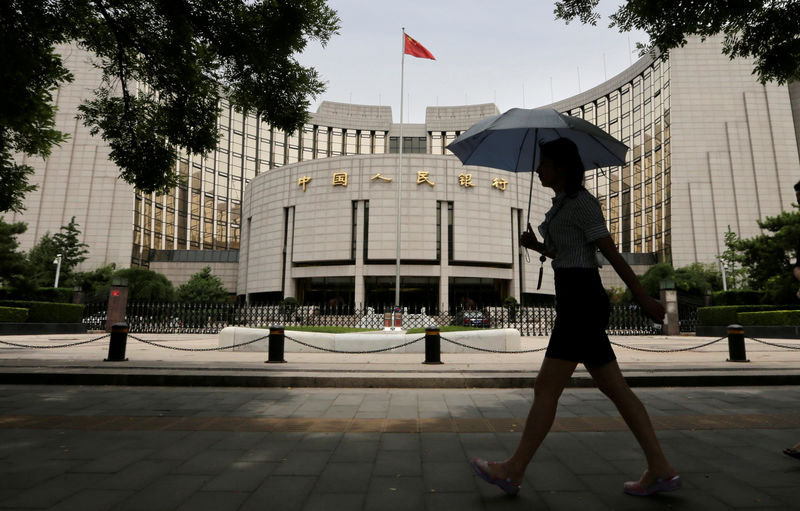 © Reuters. FILE PHOTO: Woman walks past the headquarters of the PBOC in Beijing