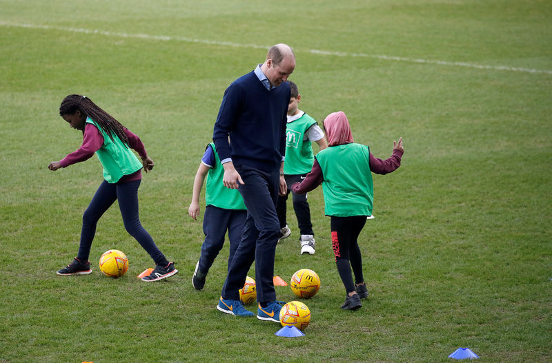 © Reuters. El príncipe Guillermo de Inglaterra y Catalina muestran sus habilidades futbolísticas