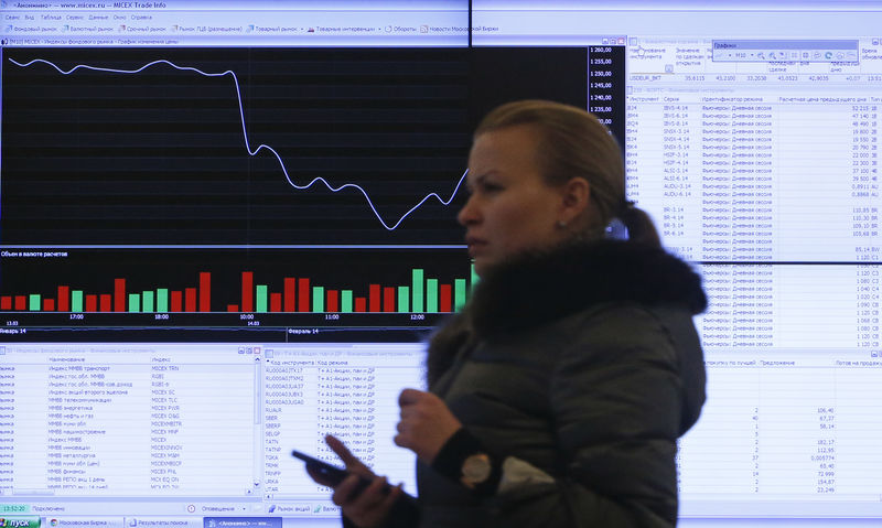 © Reuters. A woman walks past an information screen on display inside the office of the Moscow Exchange in the capital Moscow