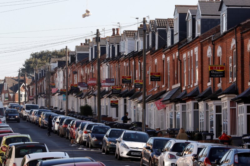 © Reuters. FILE PHOTO - Estate agent's signs hang from houses in the Selly Oak area of Birmingham