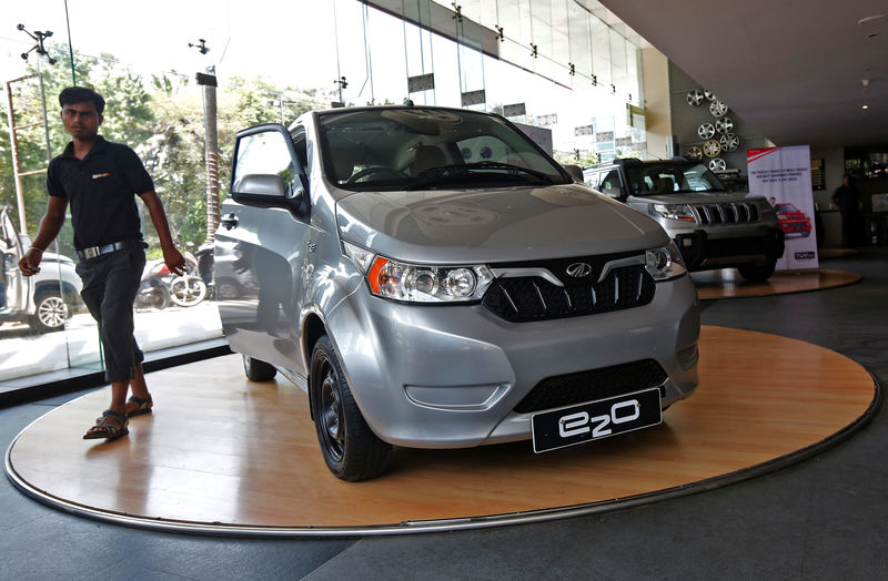 © Reuters. An employee walks past a Mahindra e2o electric car on display at Mahindra’s showroom in Mumbai