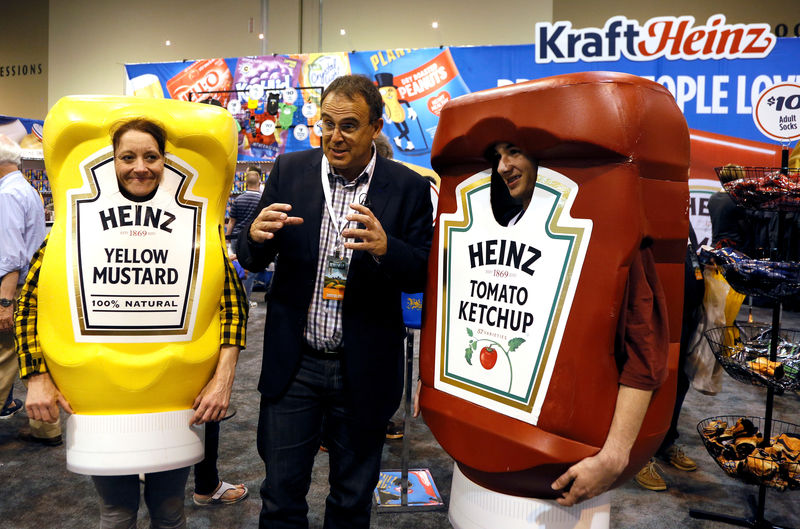 © Reuters. FILE PHOTO: Characters at the Berkshire Hathaway company Kraft Heinz booth pose with a reporter at the shareholder shopping day in Omaha