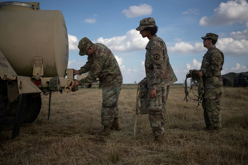 © Reuters. FILE PHOTO: Army soldiers stand in line for water at the Camp Donna military base along the United States - Mexico border in Donna, Texas