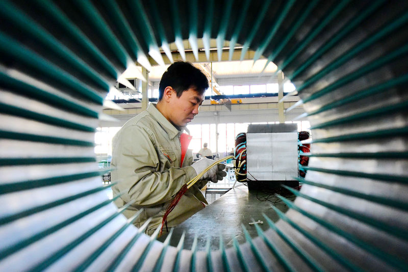 © Reuters. Man works on electric machine parts at a workshop of an equipment manufacturing company in Weifang, Shandong