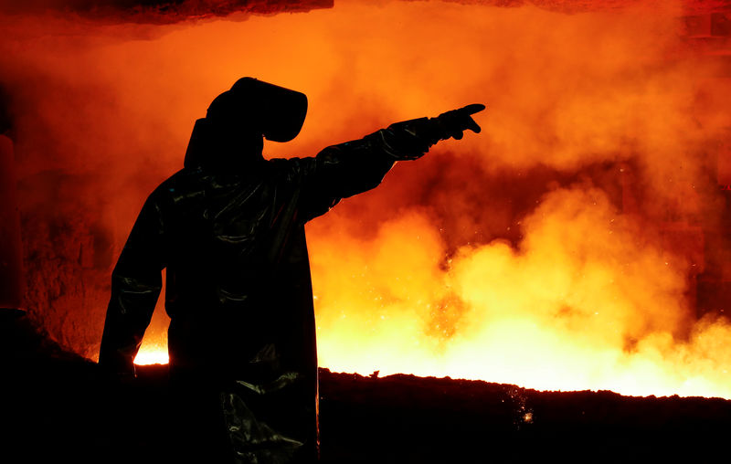 © Reuters. A steel worker of Germany's industrial conglomerate ThyssenKrupp AG gestures in his protection gear in front of a blast furnace at Germany's largest steel factory in Duisburg