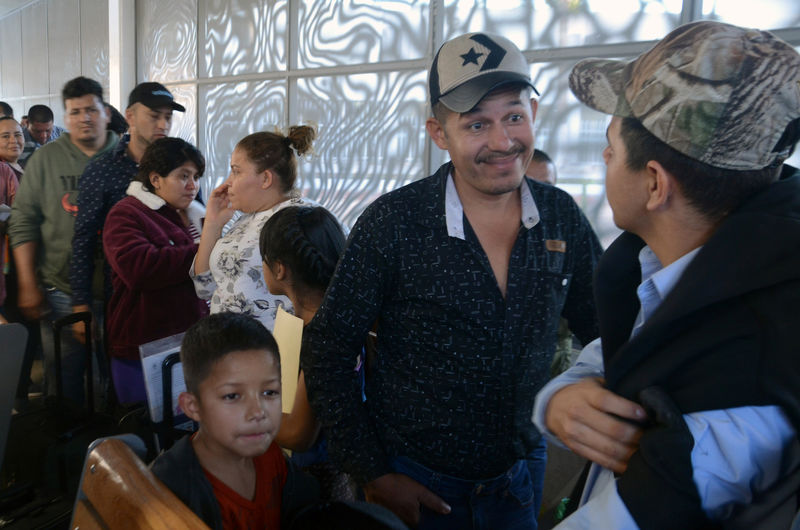 © Reuters. Central American migrants line up as they wait to enter the U.S.