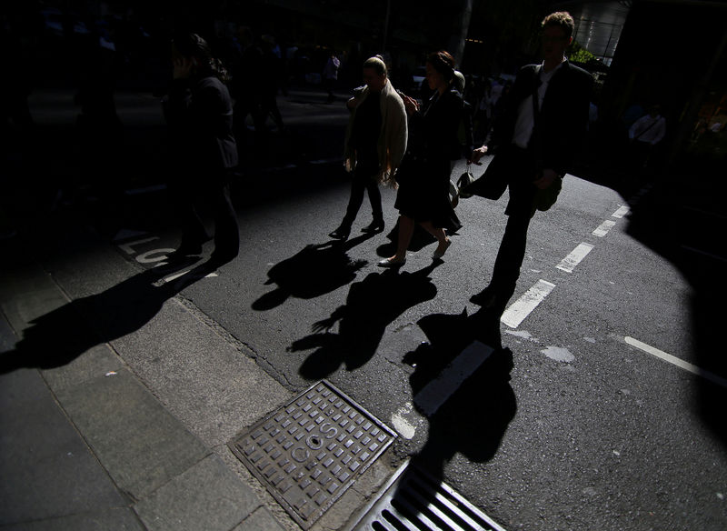 © Reuters. FILE PHOTO - Office workers cross a street in Sydney