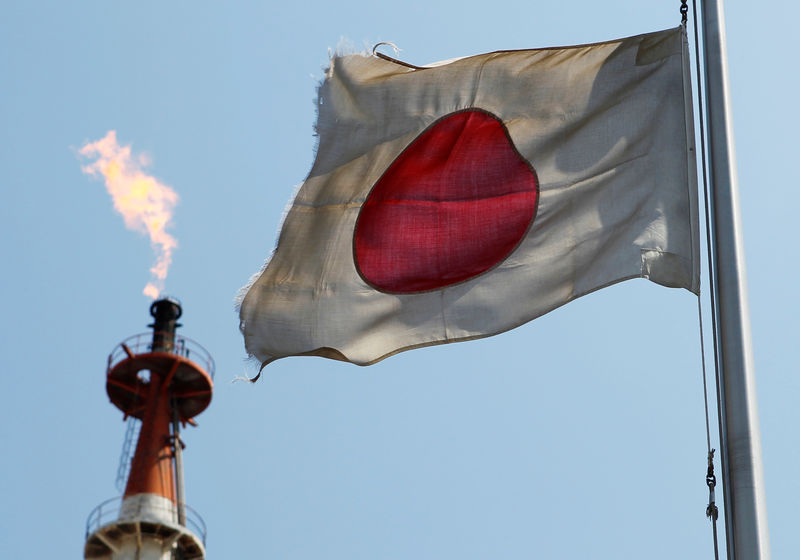 © Reuters. FILE PHOTO - A Japanese national flag flutters near a gas flare from a factory at Keihin industrial zone in Kawasaki