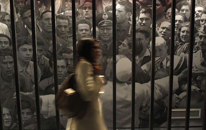 © Reuters. Una visitante pasa junto a una foto del Papa Pío XII durante una exposición en los Museos Capitolinos de Roma