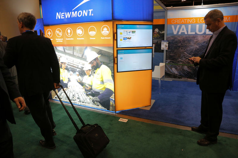 © Reuters. Visitors pass the Newmont Mining Corporation booth during the PDAC convention in Toronto