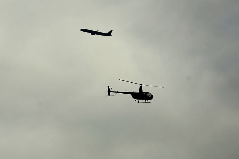 © Reuters. FILE PHOTO: A helicopter and commercial plane flies by over San Diego