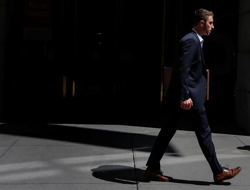 © Reuters. A man in a suit walks on Wall St. in New York