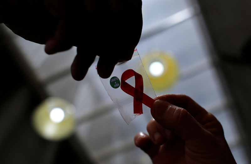 © Reuters. FILE PHOTO: Nurse gives a red ribbon to a woman to mark World Aids Day at the entrance of Emilio Ribas Hospital, in Sao Paulo