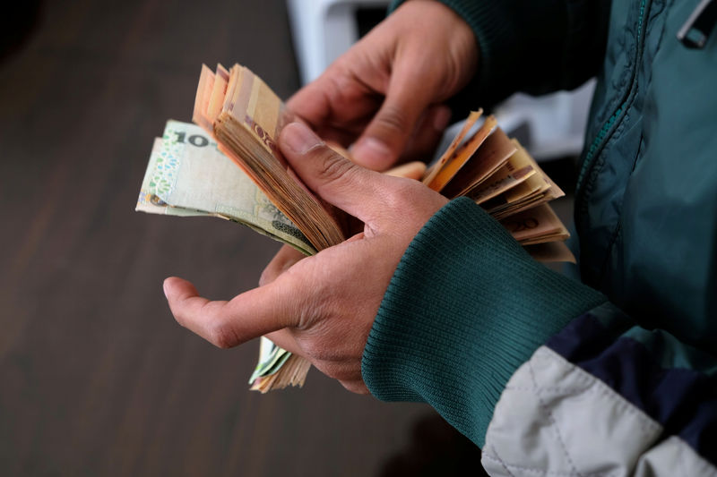 ©路透社。 一名男子在班加西的货币兑换处数钱购买美元