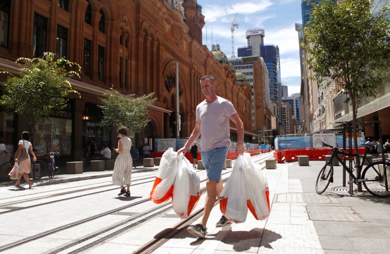 © Reuters. A man carries several shopping bags as he walks along George Street in Sydney