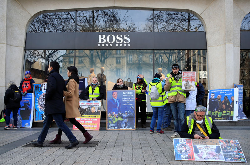 © Reuters. Protesters wearing yellow vests gather in front of a Hugo Boss store during a demonstration by the "yellow vests" movement in Paris