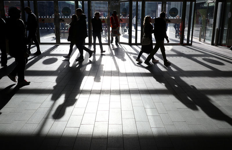 © Reuters. People's shadows are seen as shoppers are silhouetted in the bright sunshine at the Westfield shopping centre, Stratford, London