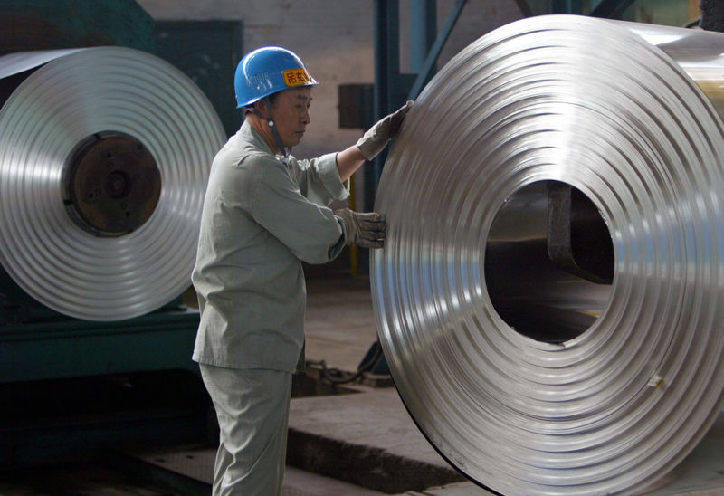 © Reuters. Trabalhador manuseia bobinas de aço em Hubei, China