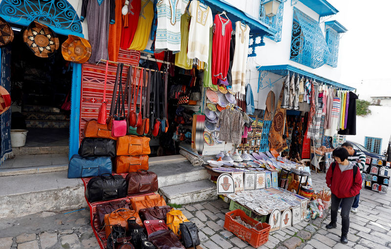 ©路透社。 一名游客在突尼斯附近的西迪布赛义德看待出售的传统纪念品