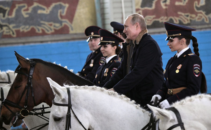 © Reuters. بوتين يحتفل باليوم العالمي للمرأة بالتنزه مع شرطيات على ظهور الخيل